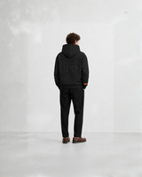 Model wearing a black Bay or Bust Anthropic signature hoodie, back view for the IPO Collection